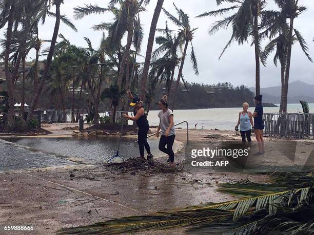 Residents clear the area of fallen trees and branches on the Hamilton Island after strong Cyclone Debbie hit the Whitsundays Islands in Queensland on...