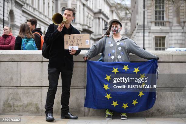 Pro-remain protestors pose outside 10 Downing Street in central London on March 29, 2017. Britain formally launches the process for leaving the...