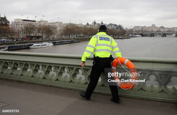 Police officer looks for a person thought to have fallen from Westminster Bridge into the River Thames on March 29, 2017 in London, England.