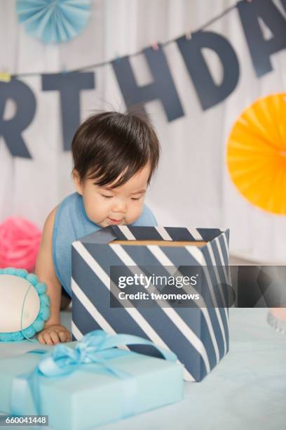 asian toddler looking into a big gift box. - jb of south korean stockfoto's en -beelden