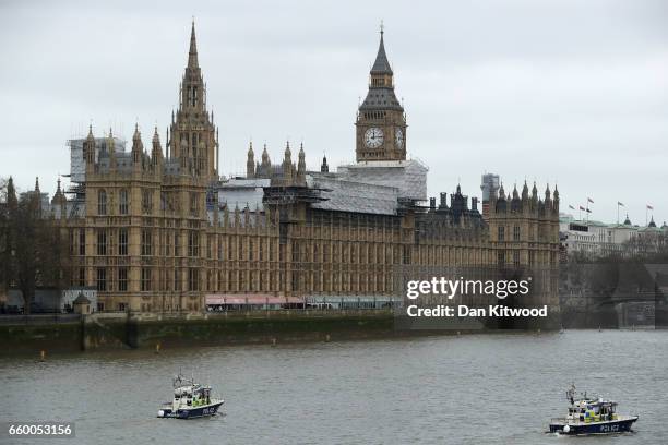 Police boats patrol outside the Houses of Parliament as they look for a person thought to have fallen from Westminster Bridge into the River Thames...