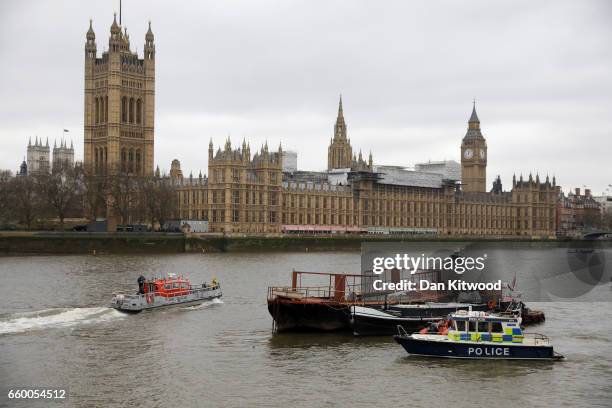 Police boats patrol outside the Houses of Parliament as they look for a person thought to have fallen from Westminster Bridge into the River Thames...