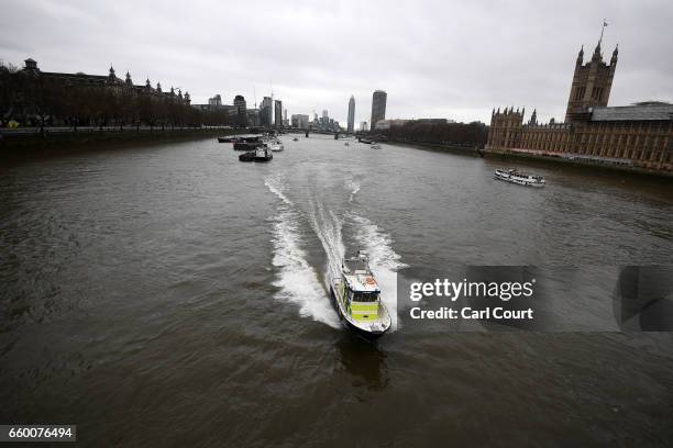 Police boat patrols the river near Westminster Bridge as they look for a person thought to have fallen from Westminster Bridge into the River Thames...