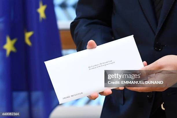 European Council President Donald Tusk holds British Prime Minister Theresa May's formal notice of the UK's intention to leave the bloc under Article...