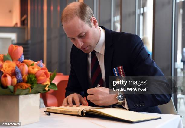 Prince William, Duke of Cambridge signs the visitors book at The National Memorial Arboretum after opening the new visitors centre on March 29, 2017...