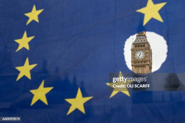 Pro-remain protester holds up an EU flag with one of the stars symbolically cut out in front of the Houses of Parliament shortly after British Prime...