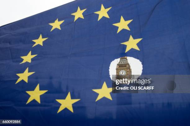 Pro-remain protester holds up an EU flag with one of the stars symbolically cut out in front of the Houses of Parliament shortly after British Prime...