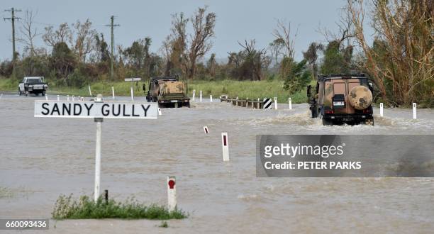 An army vehicle drives through floodwaters near the Queensland town of Bowen on March 29 after the area was hit by Cyclone Debbie. Towns remained cut...