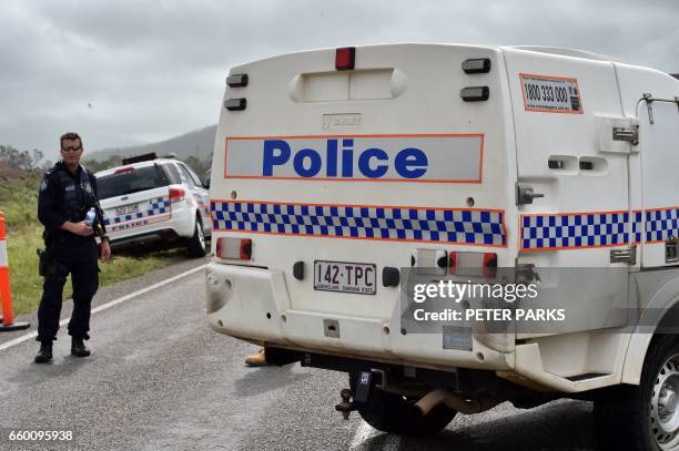 Police man a road block at floodwaters near the Queensland town of Bowen on March 29 after the area was hit by Cyclone Debbie. Towns remained cut off...