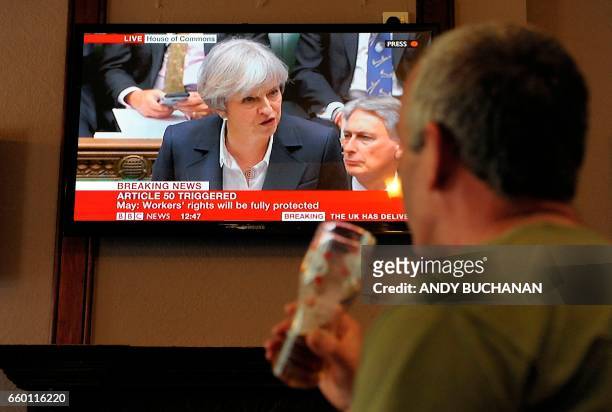 Television screen displays an image of British Prime Minister Theresa May as she speaks during Prime Minister's Questions in the Houses of Parliament...