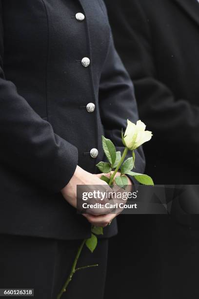 Police officer holds a white rose on Westminster Bridge during a vigil to remember the victims of last week's Westminster terrorist attack on March...