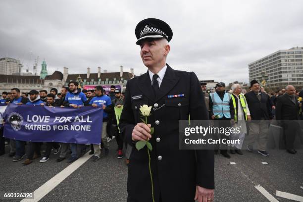 Police officer holds a white rose as he leads a vigil over Westminster Bridge during to remember the victims of last week's Westminster terrorist...