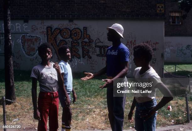 Portrait of Kansas City-Omaha Kings "Tiny" Nate Archibald with local youth outside of his former South Bronx housing project apartment at Lester...