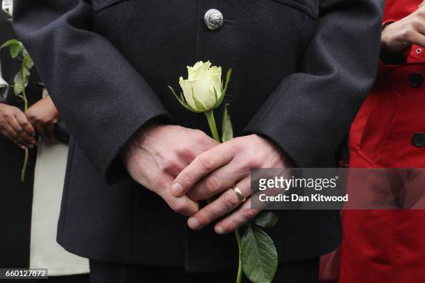 Police officer holds a white rose on Westminster Bridge during a vigil to remember the victims of last week's Westminster terrorist attack on March...