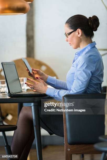 schöne brünette geschäftsfrau auf mittagspause, arbeiten am laptop im restaurant. sie trägt brille - brunette sitting at desk stock-fotos und bilder
