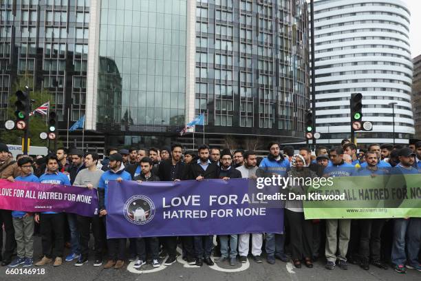 People hold banners reading 'Love for all, hatred for none' on Westminster Bridge as they attend a vigil to remember the victims of last week's...