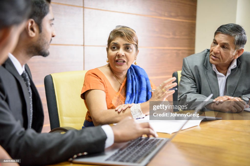 Sri Lankan woman in business meeting and young man with latop