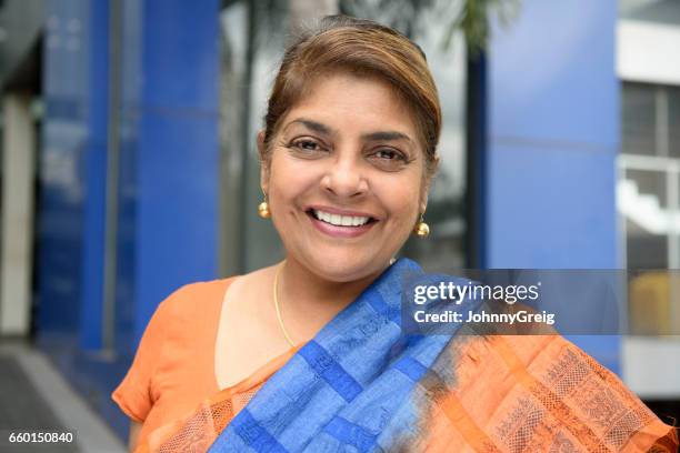 mature woman in sari outside office building, smiling - sri lankan culture stock pictures, royalty-free photos & images