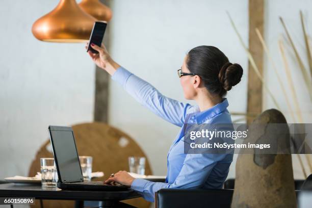 schöne brünette geschäftsfrau auf mittagspause, arbeiten am laptop im restaurant. sie trägt brille, wobei ein selbstporträt - brunette sitting at desk stock-fotos und bilder