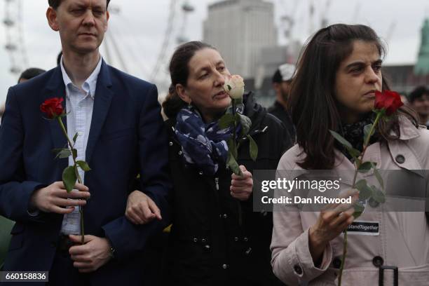 People hold roses on Westminster Bridge as they attend a vigil to remember the victims of last week's Westminster terrorist attack on March 29, 2017...