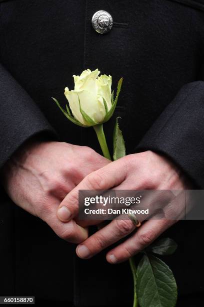 Police Officers hold roses on Westminster Bridge as they attend a vigil to remember the victims of last week's Westminster terrorist attack on March...