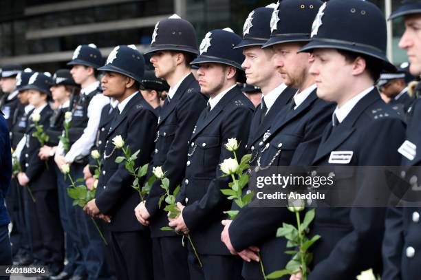 Police Officers hold flowers as they attend a vigil to remember the victims of last week's Westminster terrorist attack on March 29, 2017 in London,...