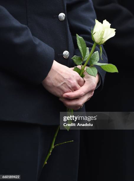 Police officers and people hold flowers as they attend a vigil to remember the victims of last week's Westminster terrorist attack on March 29, 2017...