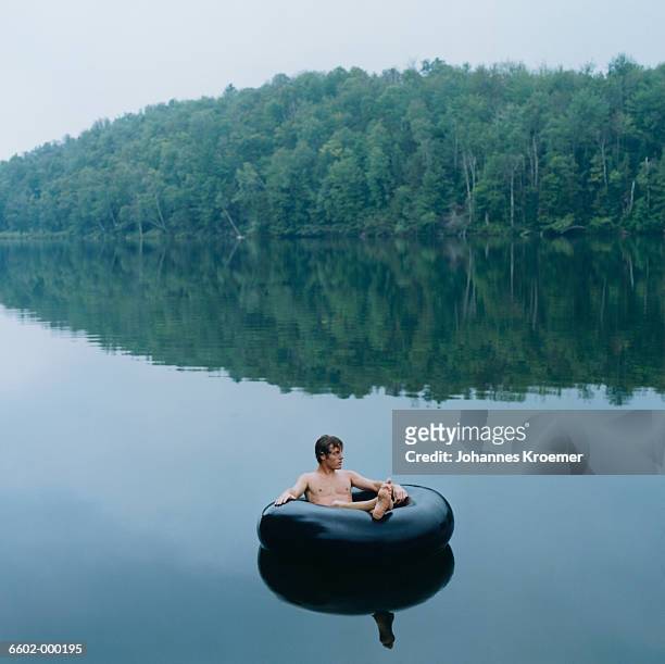 man floating in inner tube - man on float stock pictures, royalty-free photos & images
