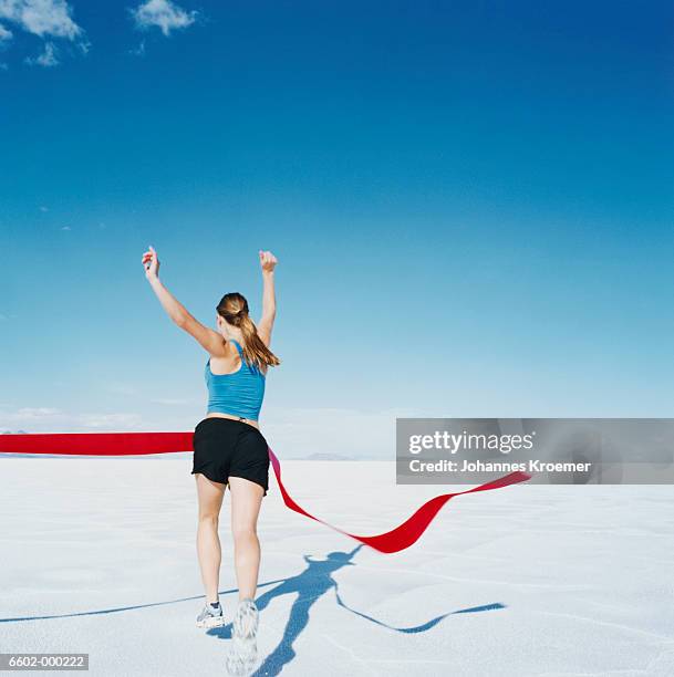 runner crossing finishing line - crossing the finishing line stock pictures, royalty-free photos & images
