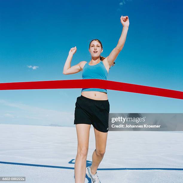 runner crossing finishing line - crossing the finishing line stock pictures, royalty-free photos & images