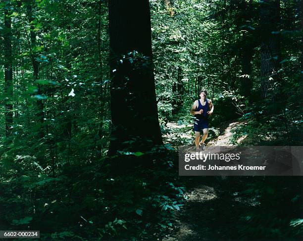 man jogging in forest - distance running ストックフォトと画像