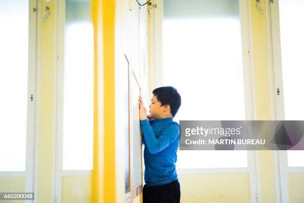Jules, a 8-year-old autistic boy, stands in a room on March 24, 2017 in Courbevoie, north-west of Paris, at the Lud'Eveil center for children with...