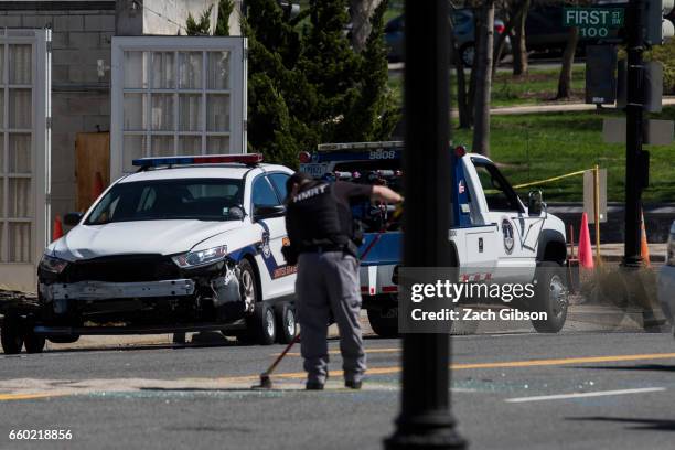 Police officer sweeps debris at the scene of an incident on March 29, 2017 on Capitol Hill in Washington, DC. U.S. Capitol Police fired shots at a...