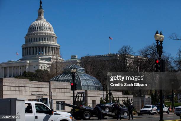 Police load a car onto a tow truck at the scene of an incident on March 29, 2017 on Capitol Hill in Washington, DC. U.S. Capitol Police fired shots...
