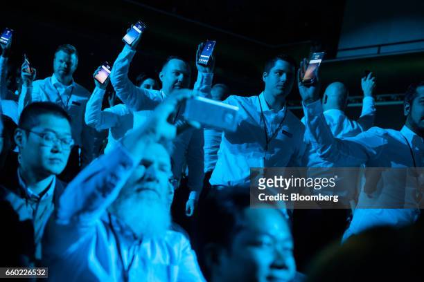 Employees hold up new Samsung Electronics Co. Galaxy S8 smartphones during the Samsung Unpacked product launch event in New York, U.S., on Wednesday,...