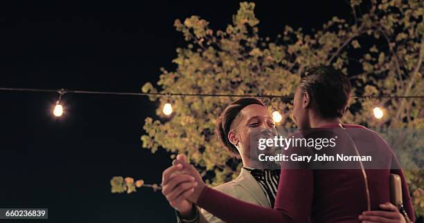 young couple dancing while out at night. - date night stock pictures, royalty-free photos & images