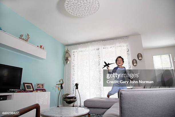 young hispanic boy plays with model plane at home - model airplane ストックフォトと画像