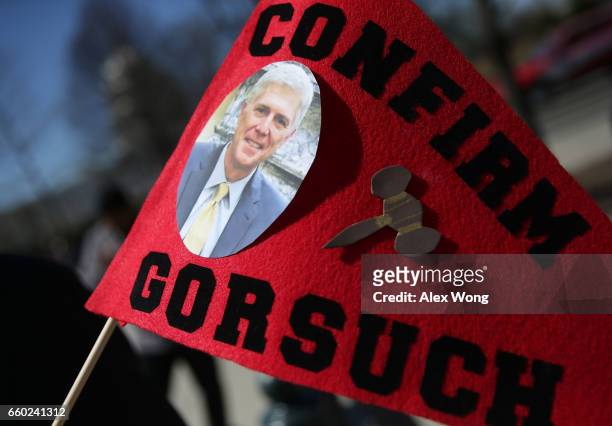 Member of Public Advocate of the U.S. Holds a sign to support the Gorsuch nomination during a news conference in front of the Supreme Court March 29,...