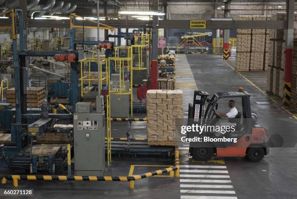 Forklift moves pallets of Empresas Polar SA P.A.N. Brand cornmeal at the company's processing and distribution facility in Turmero, Venezuela, on...