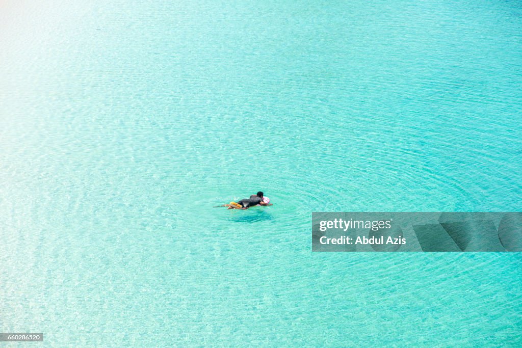 Man Swimming   at Pink Beach - The most beautiful beach in Komodo National Park - Labuan Bajo in Flores Island- East Nusa Tenggara - Indonesia