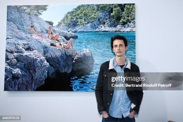 Artist Adrien Belgrand poses in front of his work during the 'Art Paris Art Fair' Exhibition Opening at Le Grand Palais on March 29, 2017 in Paris,...