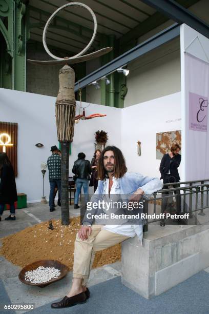 Artist Nicolas Lefebvre poses in front of his works during the 'Art Paris Art Fair' Exhibition Opening at Le Grand Palais on March 29, 2017 in Paris,...