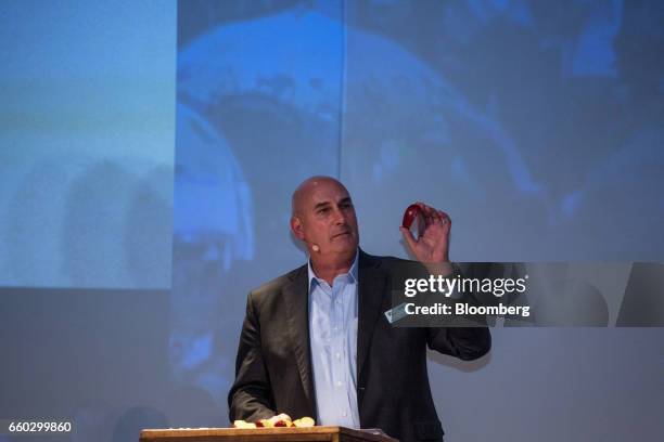 Hugh Grant, chairman and chief executive officer for Monsanto Co., holds up an apple during the Global Agribusiness Forum in Sao Paulo, Brazil, on...