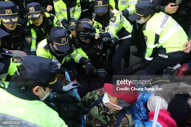 Police officers scuffle with protesters as they demand the arrest of ousted South Korean President Park Geun-hye, in front of her private home on...