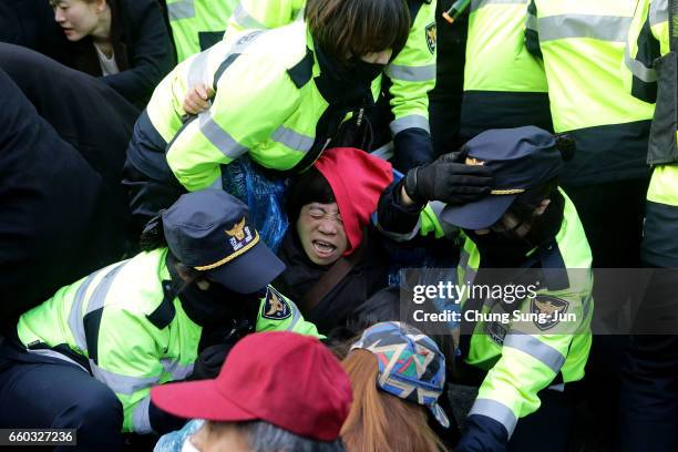 Police officers scuffle with protesters as they demand the arrest of ousted South Korean President Park Geun-hye, in front of her private home on...