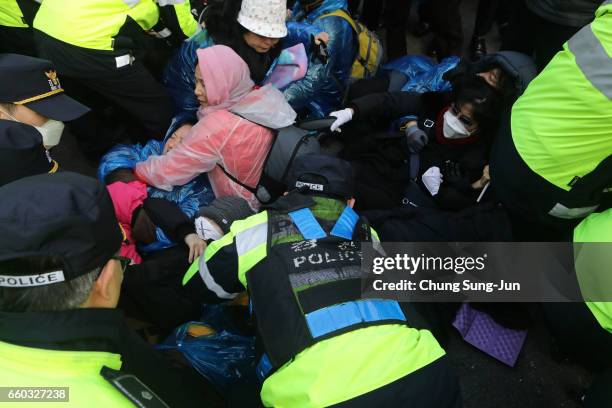 Police officers scuffle with protesters as they demand the arrest of ousted South Korean President Park Geun-hye, in front of her private home on...