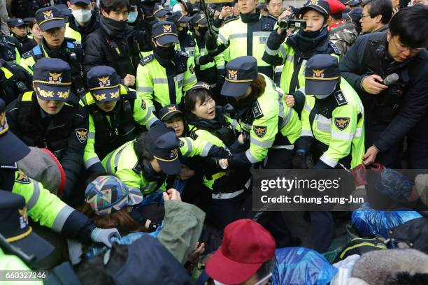 Police officers scuffle with protesters as they demand the arrest of ousted South Korean President Park Geun-hye, in front of her private home on...