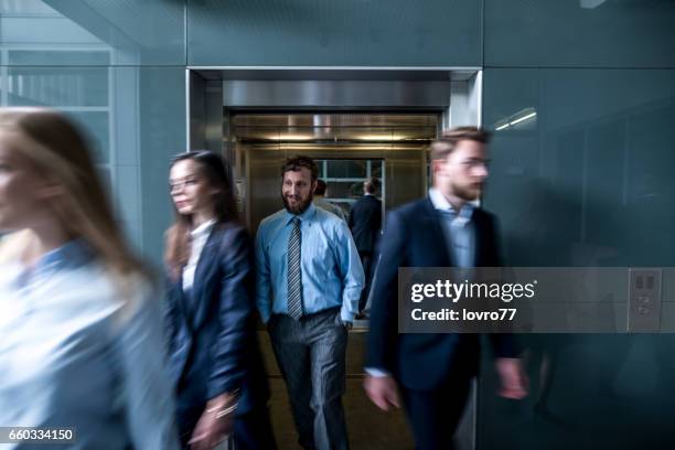 mensen uit het bedrijfsleven uit lopen van de lift in de lobby. - crowded elevator stockfoto's en -beelden