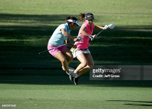 Megan Khang and amateur Victoria Arlen jump and share a laugh on the ninth fairway during a pro am at Mission Hills Country Club on March 29, 2017 in...