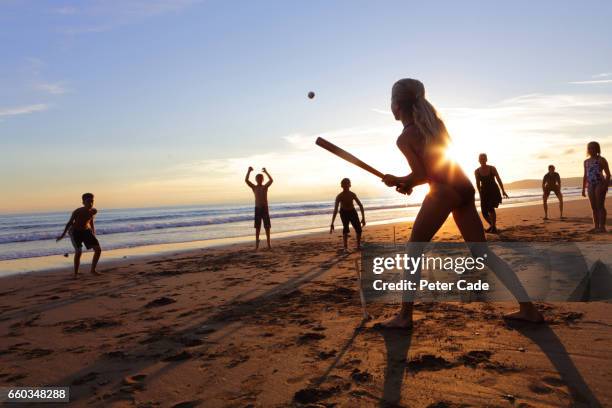 group of children and adults playing ball game on beach at sunset - batting sports activity stock pictures, royalty-free photos & images